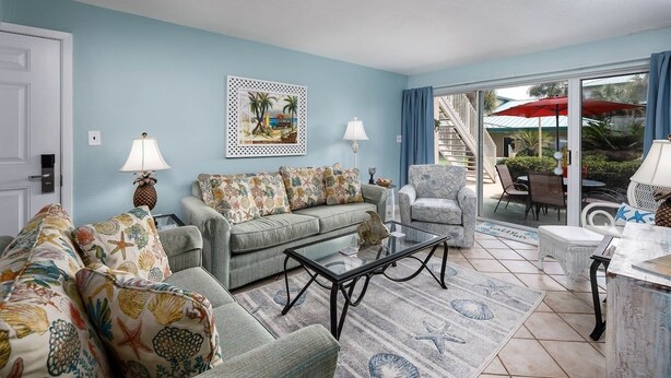 A living room with a sofa set, a coffee table, and a patterned rug.