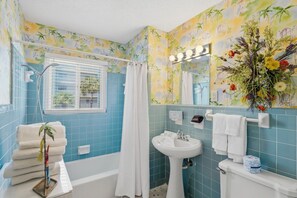 A bathroom with a bathtub, a sink, a toilet, and a shower curtain. - Seaspray Condos - 212B (Fort Walton Beach)