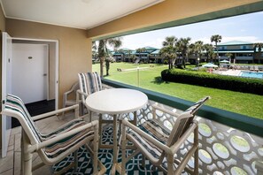 Balcón con vista a una piscina y edificios del complejo turístico.
