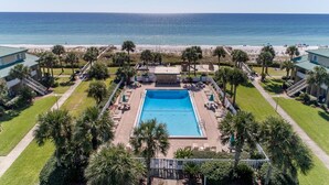 A swimming pool surrounded by palm trees and a beach view. - Seaspray Condos - 214C (Fort Walton Beach)