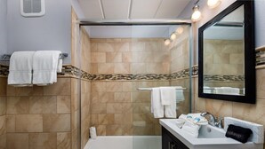 A bathroom with a glass shower enclosure, a bathtub, a sink with a vanity, and a mirror. - Seaspray Condos - 214C (Fort Walton Beach)