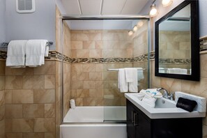 A bathroom with a glass shower enclosure, a bathtub, a sink with a vanity, and a mirror. - Seaspray Condos - 214C (Fort Walton Beach)