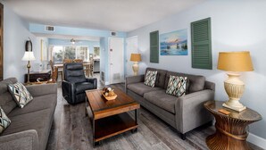 A living room with a sofa, armchair, coffee table, and decorative lamps. - Seaspray Condos - 216C (Fort Walton Beach)