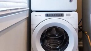 Dos lavadoras de carga frontal apiladas en un cuarto de lavado.