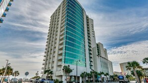 Un grand hôtel moderne à la façade incurvée et doté de nombreux balcons.