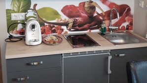 A compact kitchen with grey cabinets, a built-in dishwasher, and a sink.
