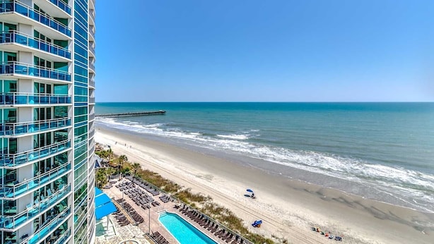 A beachfront hotel with a pool, beach access, and ocean views.