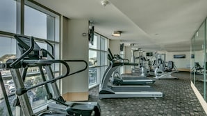 Un gimnasio con cintas de correr, elípticas y otros equipos de cardio.