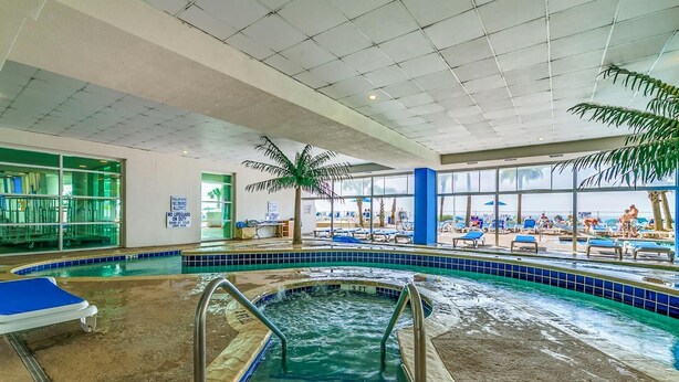 An indoor swimming pool with a 3 FT depth marker, a diving board, and a view of the beach through large windows. - · Gorgeous 3 Bedroom Condo - Pools, Lazy River, Hot Tub (Myrtle Beach)