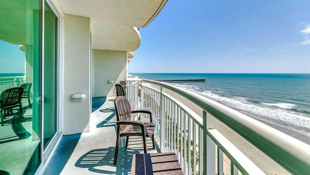 A balcony with a view of the ocean, featuring a railing and two chairs. - · Gorgeous 3 Bedroom Condo - Pools, Lazy River, Hot Tub (Myrtle Beach)