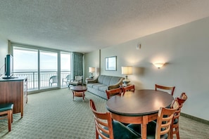 Enjoy a sea view from the balcony, featuring a dining table, sofa, and TV.