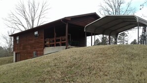 Une cabane en bois dotée d’un porche couvert et d’une structure de toit en métal.