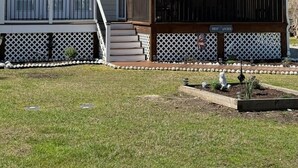 Una casa a due piani con un portico coperto, un piccolo giardino antistante e una cassetta delle lettere.