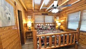 A cozy cabin interior with a wooden bed, a ceiling fan, and a rustic decor. - Rustic CreekSide Memories/5min>PForge-GBurg/HotTub (Pigeon Forge)