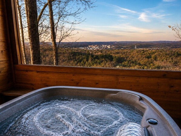 Un bain à remous avec vue sur la ville et la forêt.