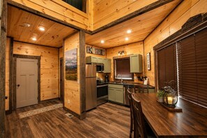 Un interior de madera con cocina, comedor y una puerta.