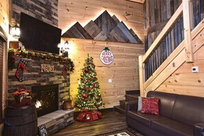 Un ambiente acogedor con chimenea, un árbol de Navidad y una escalera de madera.