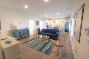 Relax in this stylish living space with a sofa, coffee table, and wicker chair.