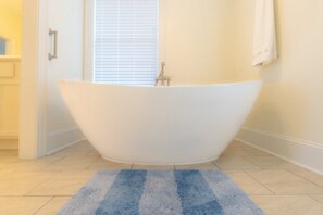 Bathroom features a bathtub and light-colored tile flooring.