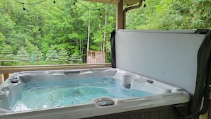 A hot tub with a wooden deck and a view of a forest. - Big Beautiful Georgian Bay Family Cottage (Tiny)