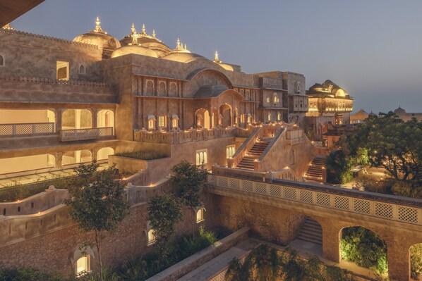 A historic building with multiple arches and domes, featuring a central staircase and a bridge connecting different sections. - Six Senses Fort Barwara (Chauth Ka Barwara)