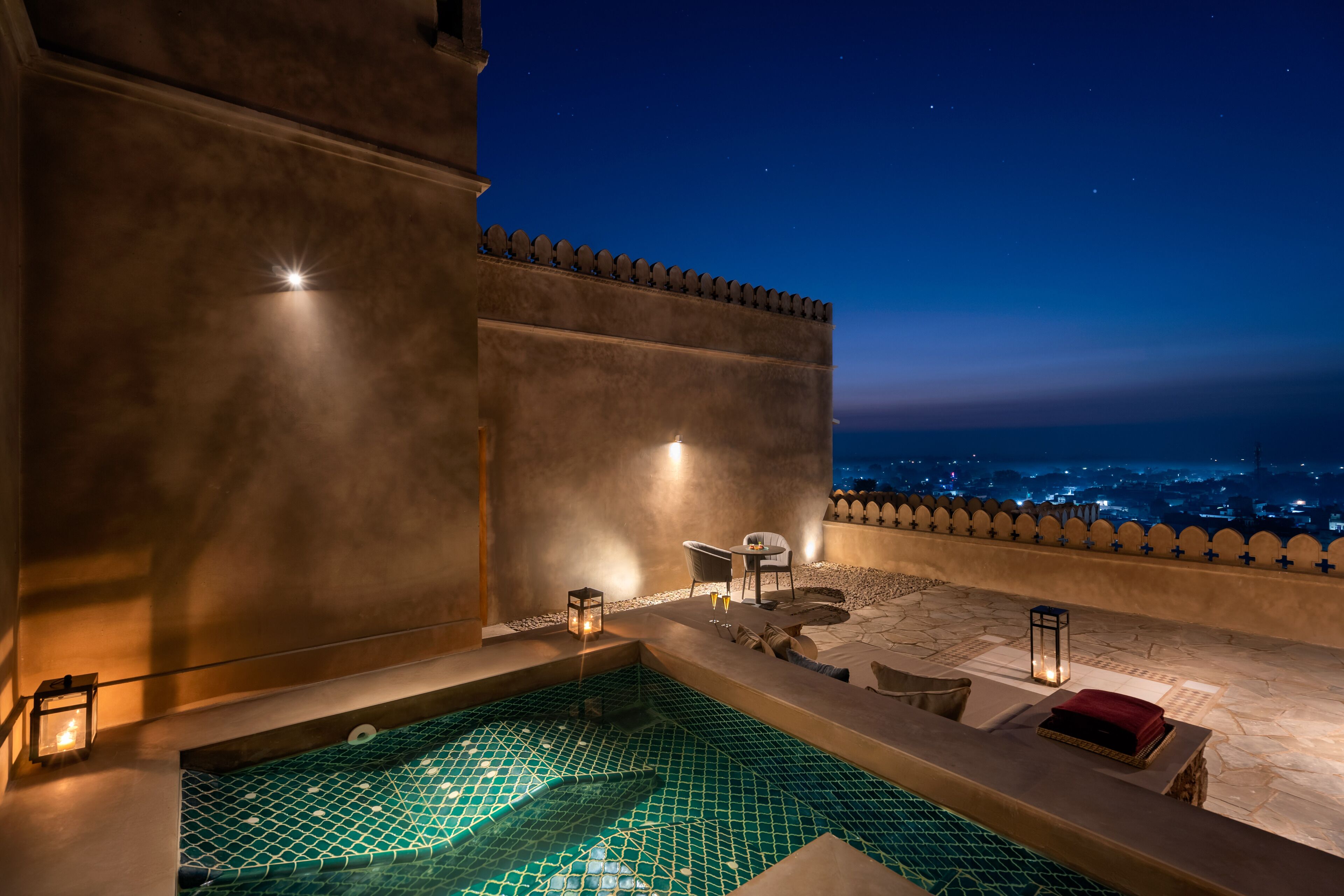 Zona de piscina al terrat amb vistes a la ciutat de nit.