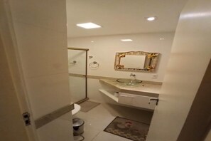 Chuveiro, toalhas de banho, sabonete, papel higiênico