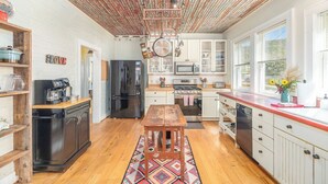A kitchen with wooden cabinets, a stainless steel refrigerator, a microwave, and a stove.