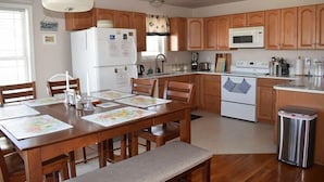 Una cocina con armarios de madera, un refrigerador blanco, un microondas y una estufa.