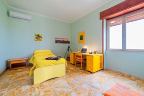 Une pièce comprenant un lit, un bureau, une chaise et une fenêtre.