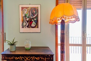 A wooden table with a framed artwork, a potted plant, and a glass bowl.