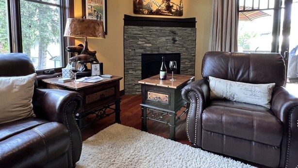 A cozy living room with leather chairs, a fireplace, and a table with a lamp. - Rs156 Downtown Whitefish Experience (Whitefish)