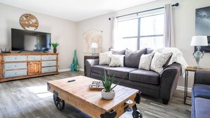 A modern living room with a sofa, coffee table, and TV.