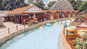 A water park with a roller coaster, a pool with inflatable rings, and a building labeled "LOCKERS".