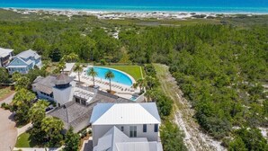 Une propriété située sur la côte, dotée d’une piscine, donnant sur la plage et entourée d’une végétation luxuriante.