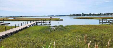 A waterfront view with wooden docks and grassy areas.