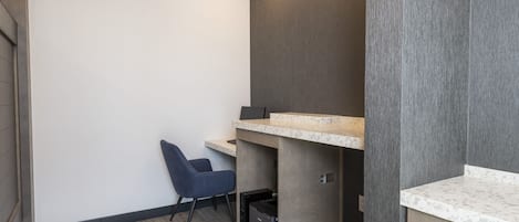 A small, modern room with a desk, chair, and built-in storage.