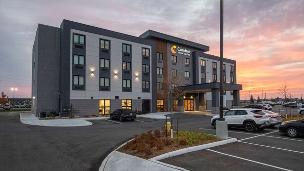 A Comfort Inn & Suites hotel with a modern design, featuring a parking lot and a clear sky at dusk. - Comfort Inn & Suites (Carleton Place)