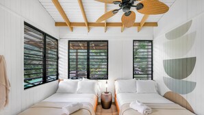 A hotel room with two beds, a ceiling fan, and large windows with black bars. - Casa Grande Mountain Retreat - Adults Only (Utuado)