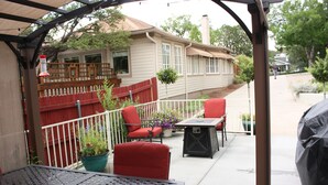 Ein überdachter Patio-Bereich mit Tisch, Stühlen und Grill.
