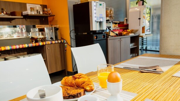 A breakfast setting with a croissant, orange juice, and a muffin on a table. - Bon Rapport Qualité-Prix! Studio Equipé + Parking (Perpignan)