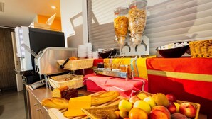 Un buffet de petit-déjeuner proposant une variété d'aliments, notamment des fruits, du pain et des condiments.