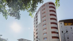 A multi-story hotel with a distinctive striped facade and balconies.