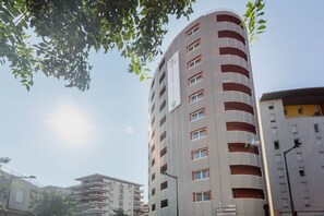 Un hôtel à plusieurs étages, doté d’une façade à rayures distinctives et de balcons.