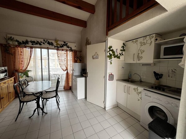 Een koelkast, een microgolfoven, kookgerei, borden en bestek