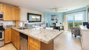 A modern kitchen with granite countertops, wooden cabinets, and stainless steel appliances.