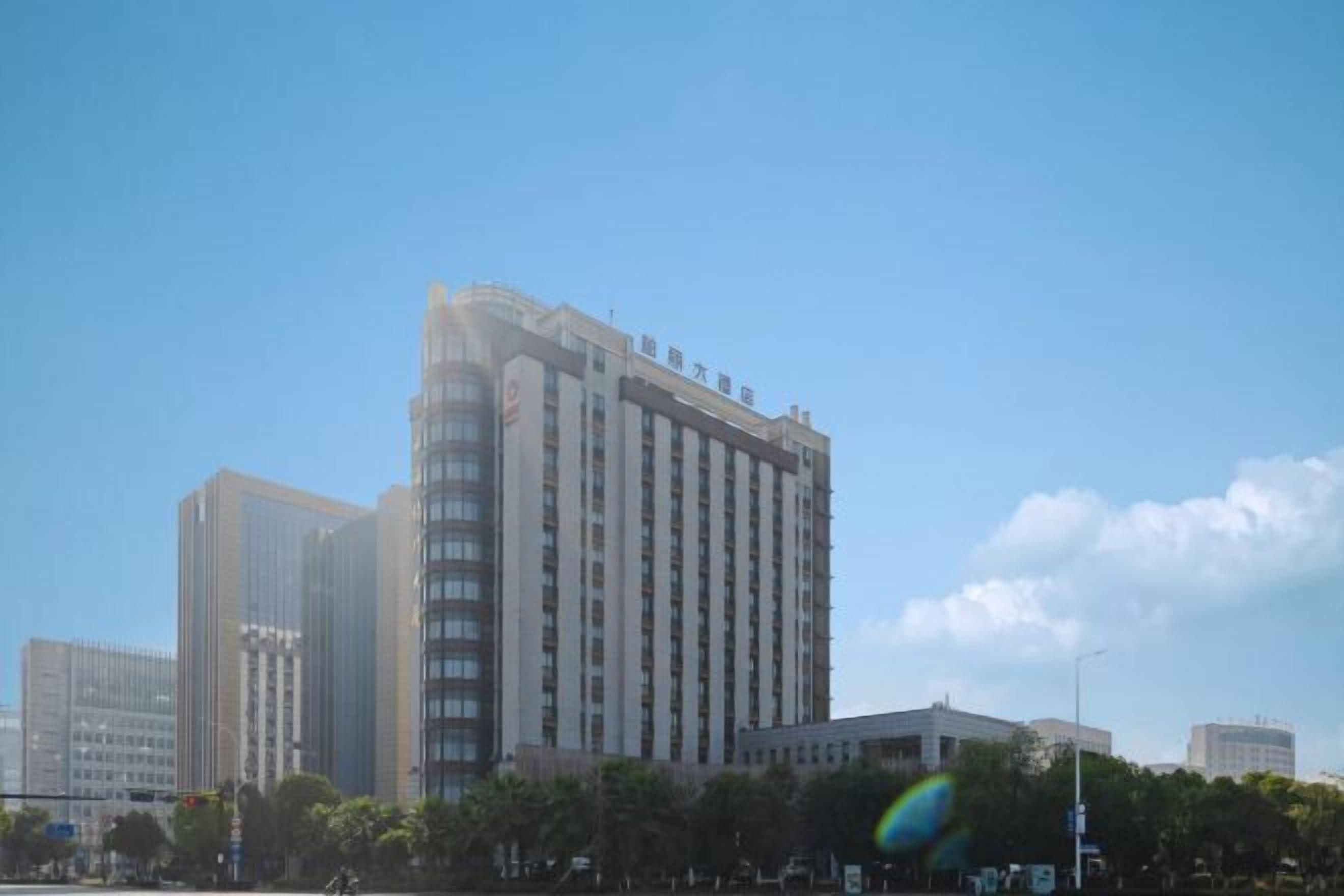 A high-rise building with a modern architectural design, featuring multiple floors and a prominent central section.