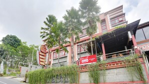 A hotel with a stone facade, red and white exterior, and a sign for 'Hotel Bergas Indah'. - OYO 4014 Hotel Bergas Indah (Bergas Kidul)