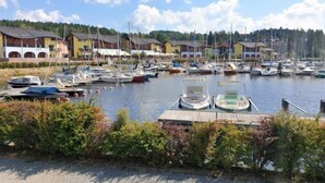 A marina with boats docked, surrounded by houses with sloped roofs.