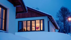 A modern house with a large window and a wooden roof.
